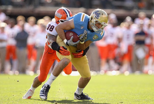 SAN FRANCISCO, CA - DECEMBER 31:  Ian Thomas #38 of the Illinois Fighting Illini tackles Joseph Fauria #8 of the UCLA Bruins during the Kraft Fight Hunger Bowl at AT&T Park on December 31, 2011 in San Francisco, California.  (Photo by Ezra Shaw/Getty Images)