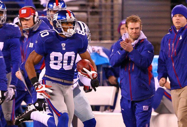 EAST RUTHERFORD, NJ - JANUARY 01:  Victor Cruz #80 of the New York Giants runs with the ball on his way to scoring a touchdown in the first quarter on a 74 yard catch and run against the Dallas Cowboys as head coach Tom Coughlin looks on from the sidelines at MetLife Stadium on January 1, 2012 in East Rutherford, New Jersey.  (Photo by Al Bello/Getty Images)
