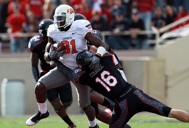 LUBBOCK, TX - NOVEMBER 12:  Justin Blackmon #81 of the Oklahoma State Cowboys is tackled by Zach Winbush #27 and Cody Davis #16 of the Texas Tech Red Raiders at Jones AT&T Stadium on November 12, 2011 in Lubbock, Texas.  (Photo by Ronald Martinez/Getty Images)