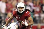 GLENDALE, AZ - JANUARY 01:  Quarterback Larry Fitzgerald #11 of the Arizona Cardinals runs with the football after a reception against the Seattle Seahawks during overtime of the NFL game at the University of Phoenix Stadium on January 1, 2012 in Glendale, Arizona. The Cardinals defeated the Seahawks 23-20 in overtime.  (Photo by Christian Petersen/Getty Images)