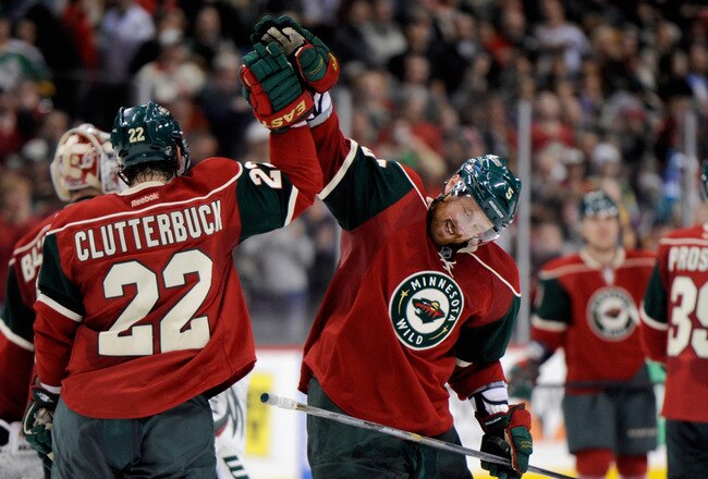 ST PAUL, MN - DECEMBER 29: Cal Clutterbuck #22 and Greg Zanon #5 of the Minnesota Wild celebrate a win against the Edmonton Oilers on December 29, 2011 at Xcel Energy Center in St Paul, Minnesota. The Wild defeated the Oilers 4-3. (Photo by Hannah Foslien/Getty Images)