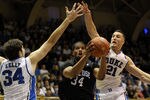 DURHAM, NC - NOVEMBER 12:   Al'Lonzo Coleman #34 of the Presbyterian Blue Hose slips through Ryan Kelly #34 and Miles Plumlee #21 of the Duke Blue Devils during an NCAA game in Cameron Indoor Stadium on November 12, 2011 in Durham, North Carolina.   (Photo by Sara D. Davis/Getty Images)