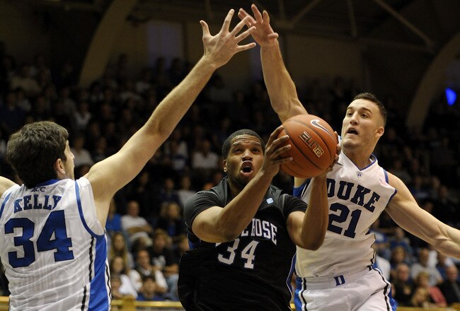 DURHAM, NC - NOVEMBER 12:   Al'Lonzo Coleman #34 of the Presbyterian Blue Hose slips through Ryan Kelly #34 and Miles Plumlee #21 of the Duke Blue Devils during an NCAA game in Cameron Indoor Stadium on November 12, 2011 in Durham, North Carolina.   (Photo by Sara D. Davis/Getty Images)
