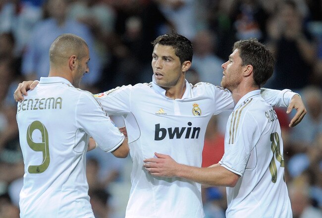 MADRID, SPAIN - SEPTEMBER 24:  Cristiano Ronaldo (C) of Real Madrid celebrates with Karim Benzema (L) and Xabi Alonso after he scored Real's 4th goal during the La Liga match between Real Madrid and Rayo Vallecano at Estadio Santiago Bernabeu on September 24, 2011 in Madrid, Spain.  (Photo by Denis Doyle/Getty Images)