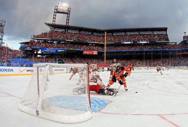 PHILADELPHIA, PA - JANUARY 02:  Claude Giroux #28 of the Philadelphia Flyers fights for the puck against Henrik Lundqvist #30 of the New York Rangers during the 2012 Bridgestone NHL Winter Classic at Citizens Bank Park on January 2, 2012 in Philadelphia, Pennsylvania.  (Photo by Rob Carr/Getty Images)