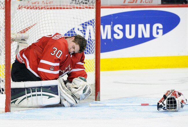 CALGARY, CANADA - JANUARY 3:  Scott Wedgewood #30 of Team Canada injured in his net after a collision with Nikita Kucherov #9 of Team Russia (not pictured) during the 2012 World Junior Hockey Championship Semifinal game at the Saddledome on January 3, 2012 in Calgary, Alberta, Canada.  (Photo by Richard Wolowicz/Getty Images)