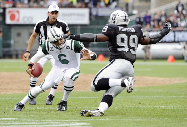 OAKLAND, CA - SEPTEMBER 25: Mark Sanchez #6 of the New York Jets escapes the tackle of Lamarr Houston #99 of the Oakland Raiders in the second quarter during an NFL football game at the O.co Coliseum September 25, 2011 in Oakland, California.  (Photo by Thearon W. Henderson/Getty Images)