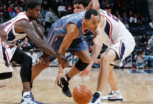 ATLANTA, GA - FEBRUARY 12:  Gerald Henderson#15 of the Charlotte Bobcats drives between Marvin Williams #24 and Zaza Pachulia #27 of the Atlanta Hawks at Philips Arena on February 12, 2011 in Atlanta, Georgia.  NOTE TO USER: User expressly acknowledges and agrees that, by downloading and/or using this Photograph, user is consenting to the terms and conditions of the Getty Images License Agreement.  (Photo by Kevin C. Cox/Getty Images)