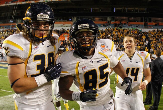 MIAMI GARDENS, FL - JANUARY 04:  (L-R) Matt Lindamood #38 Willie Milhouse #85 and Paul Millard #14 of the West Virginia Mountaineers celebrate against the Clemson Tigers  a during the Discover Orange Bowl at Sun Life Stadium on January 4, 2012 in Miami Gardens, Florida.  (Photo by Mike Ehrmann/Getty Images)