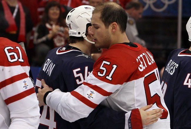 VANCOUVER, BC - FEBRUARY 28:  Bobby Ryan #54 of USA and Ryan Getzlaf #51 of Canada hug after the ice hockey men's gold medal game between USA and Canada on day 17 of the Vancouver 2010 Winter Olympics at Canada Hockey Place on February 28, 2010 in Vancouver, Canada. Canada defeated USA 3-2 in overtime. (Photo by Bruce Bennett/Getty Images)