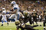 NEW ORLEANS, LA - DECEMBER 4:  Calvin Johnson #81 of the Detroit Lions breaks the tackle of Scott Shanle #58 and Patrick Robinson #21 of the New Orleans Saints to score a touchdown at Mercedes-Benz Superdome on December 4, 2011 in New Orleans, Louisiana.  The Saints defeated the Lions 31-17.  (Photo by Wesley Hitt/Getty Images)