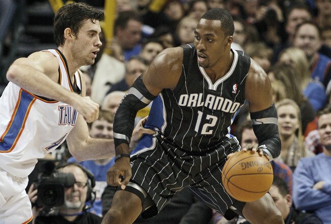 OKLAHOMA CITY, OK - DECEMBER 25:  Dwight Howard #12 of the Orlando Magic looks to drive on Nick Collison #4 of the Oklahoma City Thunder during the NBA season opening game December 25, 2011 at the Chesapeake Energy Arena in Oklahoma City, Oklahoma.  Oklahoma City defeated Orlando 97-89. NOTE TO USER: User expressly acknowledges and agrees that, by downloading and or using this Photograph, user is consenting to the terms and conditions of the Getty Images License Agreement.  (Photo by Brett Deering/Getty Images)