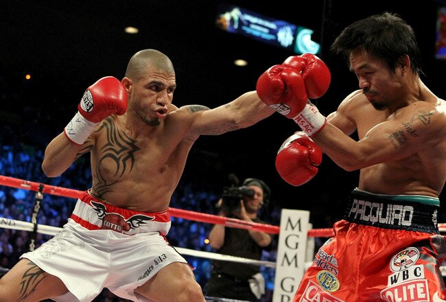 LAS VEGAS - NOVEMBER 14:  (L-R) Miguel Cotto of Puerto Rico throws a left to the head of Manny Pacquiao during their WBO welterweight title fight at the MGM Grand Garden Arena on November 14, 2009 in Las Vegas, Nevada.  (Photo by Al Bello/Getty Images)