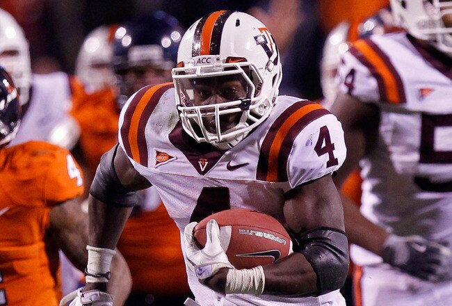 CHARLOTTESVILLE, VA - NOVEMBER 26: David Wilson #4 of the Virginia Tech Hokies runs with the ball past Rodney McLeod #4 of the Virginia Cavaliers at Scott Stadium on November 26, 2011 in Charlottesville, Virginia. (Photo by Geoff Burke/Getty Images)