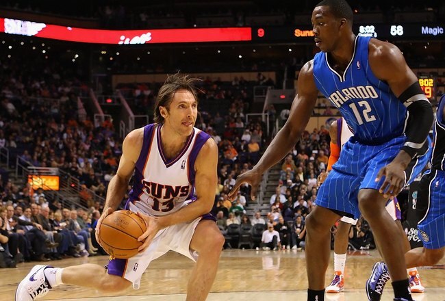 PHOENIX - DECEMBER 11:  Steve Nash #13 of the Phoenix Suns handles the ball under pessure from Dwight Howard #12 of the Orlando Magic during the NBA game at US Airways Center on December 11, 2009 in Phoenix, Arizona. The Suns defeated the Magic 106-103.  NOTE TO USER: User expressly acknowledges and agrees that, by downloading and or using this photograph, User is consenting to the terms and conditions of the Getty Images License Agreement.  (Photo by Christian Petersen/Getty Images)