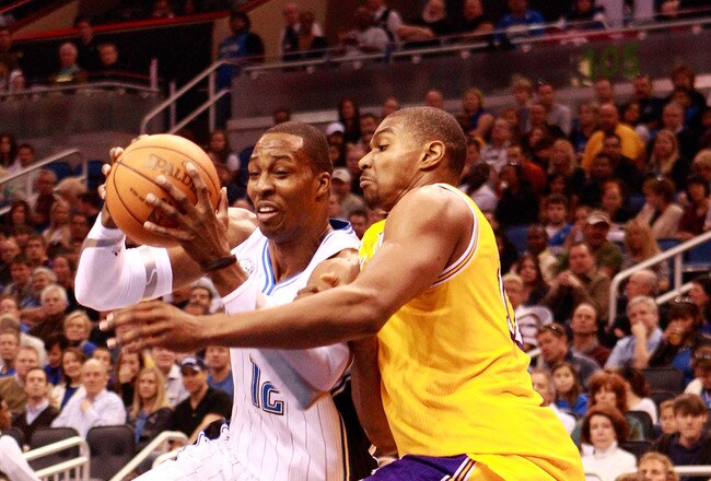 ORLANDO, FL - FEBRUARY 13:  Dwight Howard #12 of the Orlando Magic drives against Andrew Bynum #17 of the Los Angeles Lakers during the game at Amway Arena on February 13, 2011 in Orlando, Florida.  NOTE TO USER: User expressly acknowledges and agrees that, by downloading and or using this Photograph, user is consenting to the terms and conditions of the Getty Images License Agreement.  (Photo by Sam Greenwood/Getty Images)