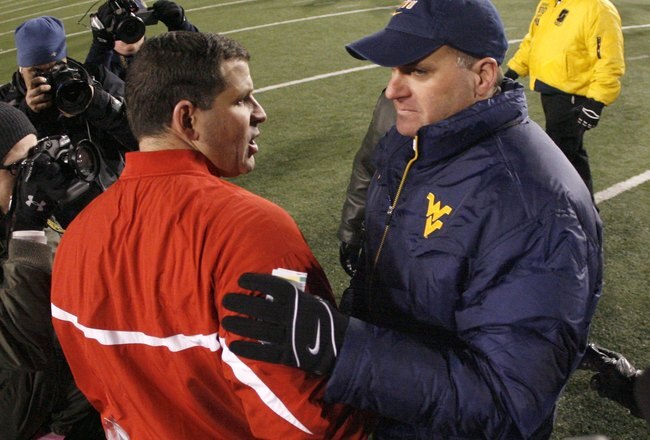 MORGANTOWN, WV - DECEMBER 2:  Rich Rodriguez head coach of the Virginia Mountaineers shakes the hand of Greg Schiano head coach of the Rutgers Scarlet Knights after a 41-39 West Virginia win at Milan Puskar Stadium December 2, 2006 in Morgantown, West Virginia.  (Photo by Gregory Shamus/Getty Images)