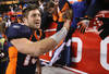 DENVER, CO - JANUARY 08:  Quarterback Tim Tebow #15 of the Denver Broncos receives high fives from fans after defeating the Pittsburgh Steelers in overtime of the AFC Wild Card Playoff game at Sports Authority Field at Mile High on January 8, 2012 in Denver, Colorado. The Broncos defeated the Steelers in overtime 23-29.  (Photo by Jeff Gross/Getty Images)