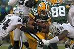 GREEN BAY, WI - DECEMBER 11: Ryan Grant #25 of the Green Bay Packers is hit by Michael Huff #24 and Lamarr Houston #99 of the Oakland Raiders at Lambeau Field on December 11, 2011 in Green Bay, Wisconsin. (Photo by Jonathan Daniel/Getty Images)