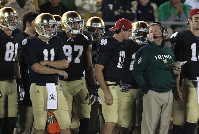 SOUTH BEND, IN - OCTOBER 22:  Head coach Brian Kelly of the Notre Dame Fighting Irish looks at Tommy Rees #11 during a game against the University of Southern California Trojans at Notre Dame Stadium on October 22, 2011 in South Bend, Indiana. USC defeated Notre Dame 31-17.  (Photo by Jonathan Daniel/Getty Images)