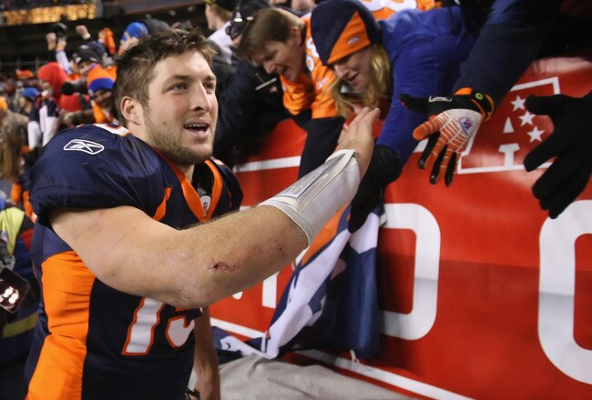 DENVER, CO - JANUARY 08:  Quarterback Tim Tebow #15 of the Denver Broncos receives high fives from fans after defeating the Pittsburgh Steelers in overtime of the AFC Wild Card Playoff game at Sports Authority Field at Mile High on January 8, 2012 in Denver, Colorado. The Broncos defeated the Steelers in overtime 23-29.  (Photo by Jeff Gross/Getty Images)