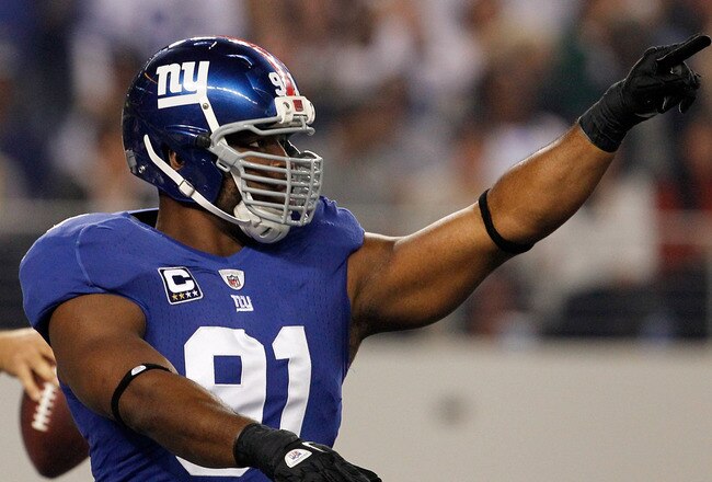 ARLINGTON, TX - DECEMBER 11:   Chris Canty #99 of the New York Giants and Justin Tuck #91 of the New York Giants celebrate after sacking  Tony Romo #9 of the Dallas Cowboys in the end zone for a safety at Cowboys Stadium on December 11, 2011 in Arlington, Texas.  (Photo by Tom Pennington/Getty Images)