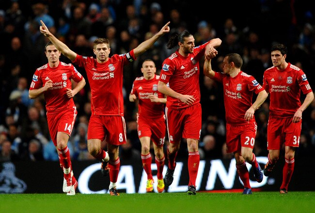 MANCHESTER, ENGLAND - JANUARY 11:  Steven Gerrard of Liverpool celebrates scoring the opening goal from a penalty kick with his team mates during the Carling Cup Semi Final First Leg match between Manchester City and Liverpool at the Etihad Stadium on January 11, 2012 in Manchester, England.  (Photo by Laurence Griffiths/Getty Images)