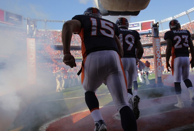 DENVER, CO - JANUARY 08:  Quarterback Tim Tebow #15 of the Denver Broncos takes the field along with teammates Eddie Royal #19 and Willis McGahee #23 to face the Pittsburgh Steelers at Sports Authority Field at Mile High on January 8, 2012 in Denver, Colorado. The Broncos defeated the Steelers 29-23 in overtime.  (Photo by Doug Pensinger/Getty Images)