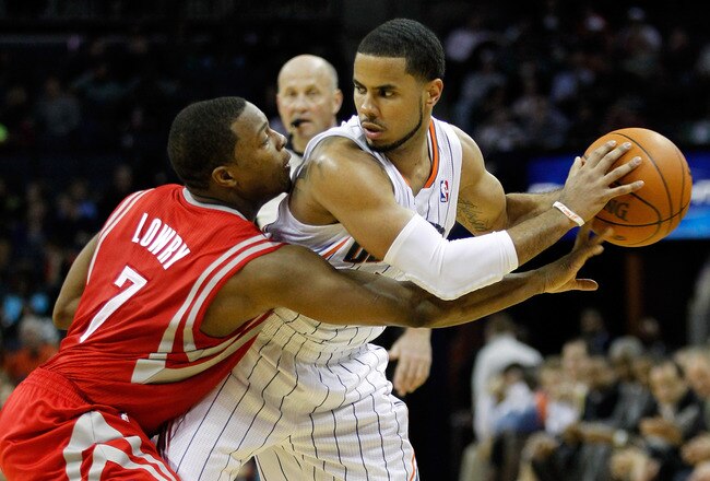CHARLOTTE, NC - JANUARY 10:  Kyle Lowry #7 of the Houston Rockets tries to steal the ball away from D.J. Augustin #14 of the Charlotte Bobcats during their game at Time Warner Cable Arena on January 10, 2012 in Charlotte, North Carolina.   NOTE TO USER: User expressly acknowledges and agrees that, by downloading and or using this photograph, User is consenting to the terms and conditions of the Getty Images License Agreement.  (Photo by Streeter Lecka/Getty Images)