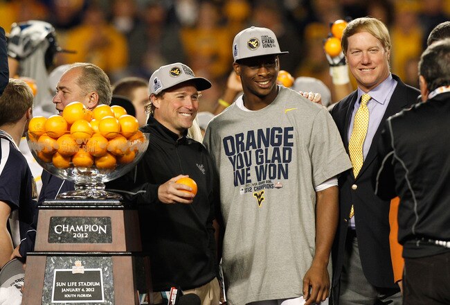 MIAMI GARDENS, FL - JANUARY 04:  (L-R) Head coach Dana Holgorsen and Geno Smith #12 of the West Virginia Mountaineers celebrate after they won 70-33 against the Clemson Tigers during the Discover Orange Bowl at Sun Life Stadium on January 4, 2012 in Miami Gardens, Florida.  (Photo by J. Meric/Getty Images)
