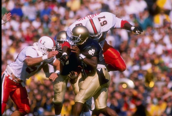 15 Oct 1988:  Defensive tackle Russell Maryland #67 and defensive end Bill Hawkins #54 of the Miami Hurricanes hit quarterback Tony Rice of the Notre Dame Fighting Irish during a game against the Fighting Irish at Notre Dame Stadium in South Bend, Indiana.  Notre Dame won the game 31-30. Mandatory Credit: Jonathan Daniel  /Allsport