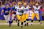 EAST RUTHERFORD, NJ - DECEMBER 04:  Aaron Rodgers #12 of the Green Bay Packers runs with the ball against the New York Giants at MetLife Stadium on December 4, 2011 in East Rutherford, New Jersey.  (Photo by Chris Trotman/Getty Images)