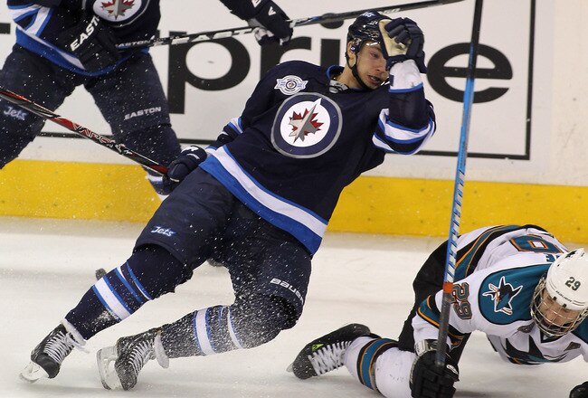 WINNIPEG, CANADA - JANUARY 12: Alexander Burmistrov #8 of the Winnipeg Jets collides with Ryane Clowe #29 of the San Jose Sharks in NHL action at the MTS Centre on January 12, 2012 in Winnipeg, Manitoba, Canada. (Photo by Marianne Helm/Getty Images)