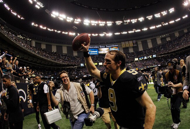 NEW ORLEANS, LA - JANUARY 07:   Drew Brees #9 of the New Orleans Saints holds the ball in the air as he runs off the field after defeating the Detroit Lions by a score of 45-28 to win during their 2012 NFC Wild Card Playoff game at Mercedes-Benz Superdome on January 7, 2012 in New Orleans, Louisiana.  (Photo by Chris Graythen/Getty Images)