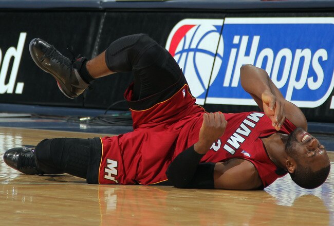 DENVER, CO - JANUARY 13:  Dwyane Wade #3 of the Miami Heat falls to the court with an injury in the fourth quarter against the Denver Nuggets at the Pepsi Center on January 13, 2012 in Denver, Colorado. Wade left the game after the injury as the Nuggets defeated the Heat 117-104. NOTE TO USER: User expressly acknowledges and agrees that, by downloading and or using this photograph, User is consenting to the terms and conditions of the Getty Images License Agreement.  (Photo by Doug Pensinger/Getty Images)