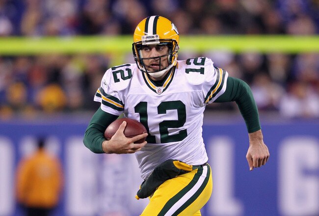 EAST RUTHERFORD, NJ - DECEMBER 04:  Aaron Rodgers #12 of the Green Bay Packers runs with the ball against the New York Giants at MetLife Stadium on December 4, 2011 in East Rutherford, New Jersey.  (Photo by Nick Laham/Getty Images)