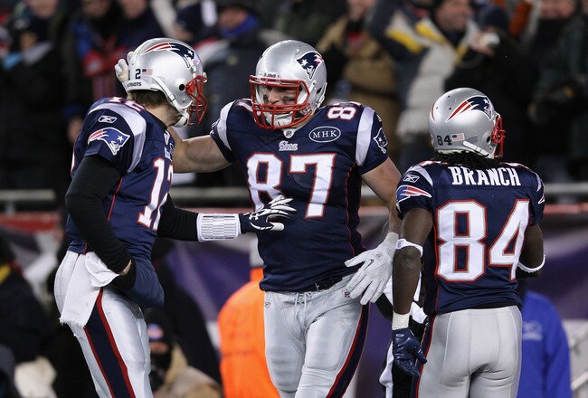 FOXBORO, MA - JANUARY 14:  (L-R) Tom Brady #12, Rob Gronkowski #87 and Deion Branch #84 of the New England Patriots celebrate after Gronkowski caught a 10-yard touchdown reception from Brady in the first quarter against the Denver Broncos during their AFC Divisional Playoff Game at Gillette Stadium on January 14, 2012 in Foxboro, Massachusetts.  (Photo by Elsa/Getty Images)
