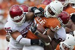 DALLAS, TX - OCTOBER 8:   Malcolm Brown #28 of the Texas Longhorns is tackled by the defense of the Oklahoma Sooners at the Cotton Bowl on October 8, 2011 in Dallas, Texas.  The Sooners defeated the Longhorns 55 to 17.  (Photo by Wesley Hitt/Getty Images)