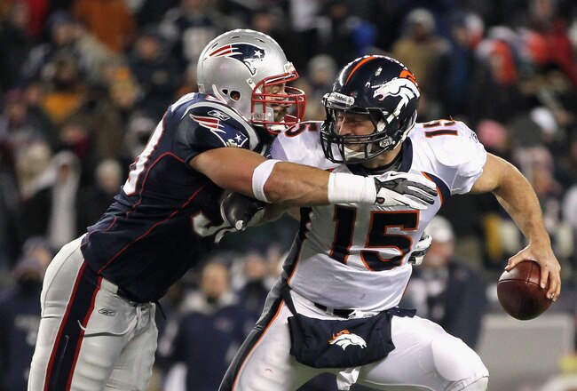 FOXBORO, MA - JANUARY 14:  Tim Tebow #15 (R) of the Denver Broncos is pressured by Rob Ninkovich #50 of the New England Patriots during their AFC Divisional Playoff Game at Gillette Stadium on January 14, 2012 in Foxboro, Massachusetts.  (Photo by Jim Rogash/Getty Images)