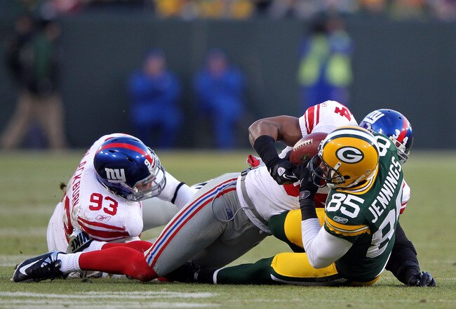 GREEN BAY, WI - JANUARY 15:   Deon Grant #34 of the New York Giants attempts to strip the ball from Greg Jennings #85 of the Green Bay Packers in t he second quarter during their NFC Divisional playoff game at Lambeau Field on January 15, 2012 in Green Bay, Wisconsin. the play was challenged and reviewed and ruled a completion.  (Photo by Jamie Squire/Getty Images)