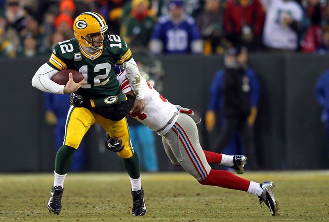 GREEN BAY, WI - JANUARY 15:   Deon Grant #34 of the New York Giants tackles  Aaron Rodgers #12 of the Green Bay Packers during their NFC Divisional playoff game at Lambeau Field on January 15, 2012 in Green Bay, Wisconsin.  (Photo by Jamie Squire/Getty Images)