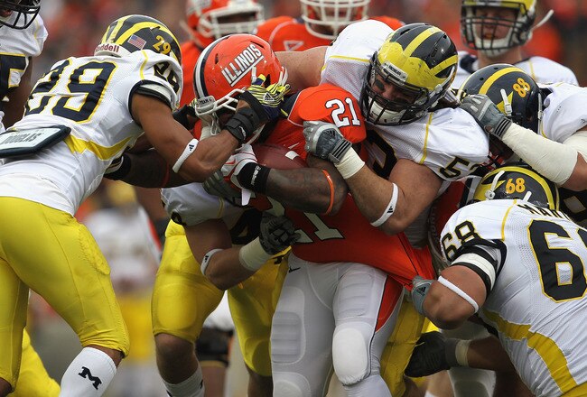 CHAMPAIGN, IL - NOVEMBER 12:  Jason Ford #21 of the Illinois Fighting Illini is tackled for a loss by (L-R) Troy Woolfolk #29, Desmond Morgan #44, Ryan Van Bergen #53, Craig Roh #88 and Mike Martin #68 of the Michigan Wolvories at Memorial Stadium on November 12, 2011 in Champaign, Illinois.  (Photo by Jonathan Daniel/Getty Images)