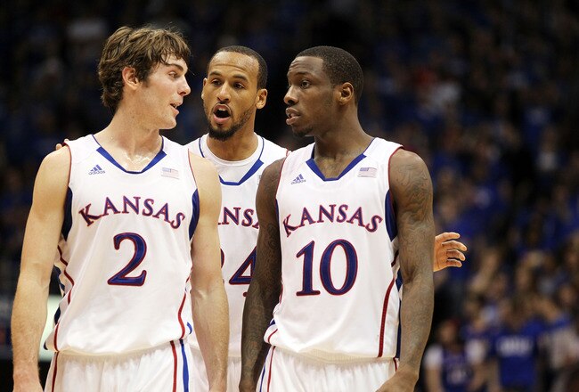 LAWRENCE, KS - JANUARY 04:  Connor Teahen #2, Travis Releford #24 and Tyshawn Taylor #10 of the Kansas Jayhawks confer during the game against the Kansas State Wildcats on January 4, 2012 at Allen Fieldhouse in Lawrence, Kansas.  (Photo by Jamie Squire/Getty Images)
