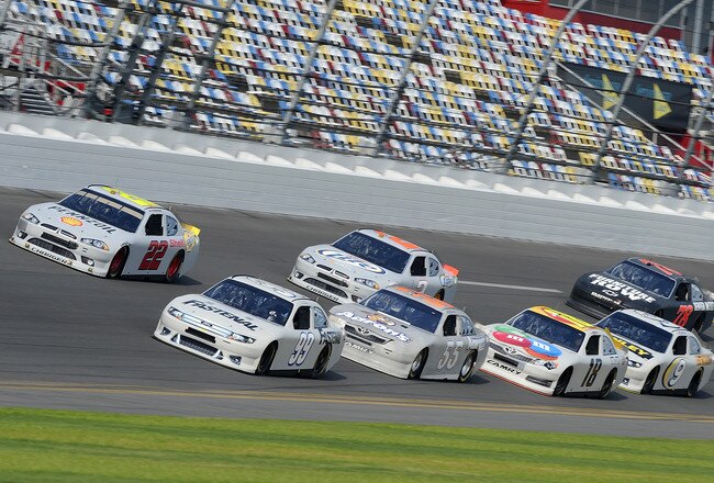 DAYTONA BEACH, FL - JANUARY 14:  Carl Edwards, driver of the #99 Fastenal Ford, and A.J. Allmendinger, driver of the #22 Shell/Pennzoil Dodge, lead a pack of cars through the tri-oval during Daytona Preseason Thunder at Daytona International Speedway on January 14, 2012 in Daytona Beach, Florida.  (Photo by Jared C. Tilton/Getty Images for NASCAR)
