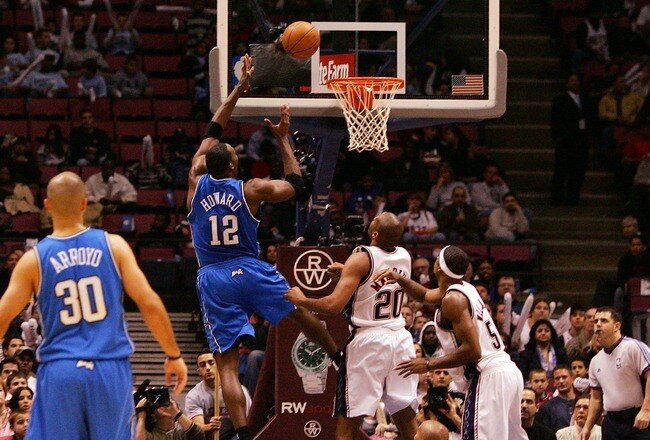 EAST RUTHERFORD, NJ - NOVEMBER 16:  Dwight Howard #12 of the Orlando Magic goes up for a basket against the New Jersey Nets during their game at the Izod Center on November 16, 2007 in East Rutherford, New Jersey. NOTE TO USER: User expressly acknowledges and agrees that, by downloading and/or using this Photograph, User is consenting to the terms and conditions of the Getty Images License Agreement.  (Photo by Jim McIsaac/Getty Images)