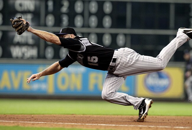HOUSTON - SEPTEMBER 25:  Third baseman Kevin Kouzmanoff #15 of the Colorado Rockies makes a diving catch on line drive off the bat of Carlos Lee #45 of the Houston Astrows in the fourth inning at Minute Maid Park on September 25, 2011 in Houston, Texas. Colorado won 19-2.  (Photo by Bob Levey/Getty Images)