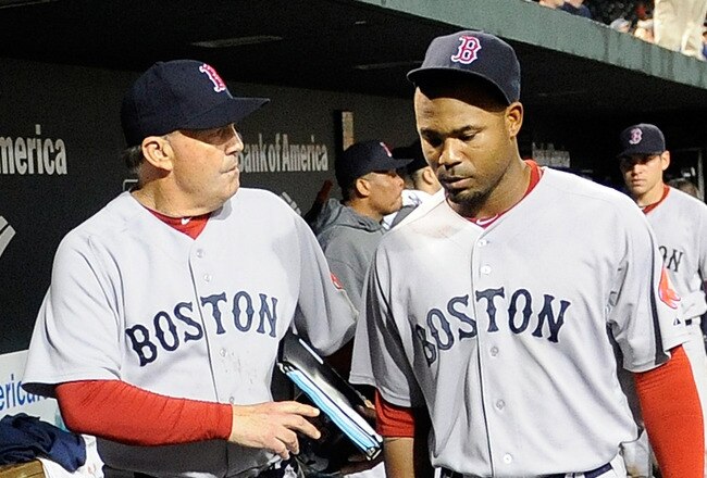 BALTIMORE, MD - SEPTEMBER 28: Carl Crawford #13 of the Boston Red Sox walks in the dugout with first base coach Ron Johnson #50 after a 4-3 loss against the Baltimore Orioles at Oriole Park at Camden Yards on September 28, 2011 in Baltimore, Maryland.  (Photo by Greg Fiume/Getty Images)