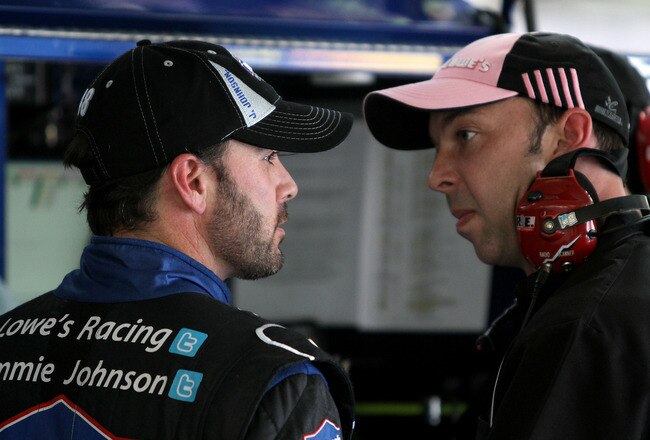 CHARLOTTE, NC - OCTOBER 13:  Jimmie Johnson (L), driver of the #48 Lowe's/Chevy 100th Anniversay Chevrolet, talks with his crew chief Chad Knaus during practice for the NASCAR Sprint Cup Series Bank of America 500 at Charlotte Motor Speedway on October 13, 2011 in Charlotte, North Carolina.  (Photo by Jerry Markland/Getty Images for NASCAR)
