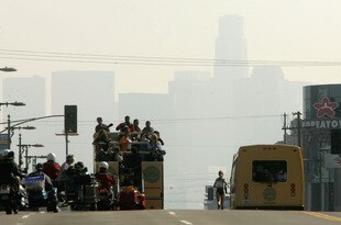 LOS ANGELES - MARCH 6:  Lyubov Denisova surorounded by a motorized press and officals entourage leads in mile 23 as she heads toward the downtown skyline during the Los Angeles Marathon XX on March 6, 2005 in Los Angeles, California. Denisova won the elite women's division.  (Photo by Stephen Dunn/Getty Images)