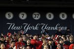 NEW YORK - DECEMBER 30:  Fans of the Rutgers Scarlet Knights cheer in front of the wall of retired New York Yankees numbers during the New Era Pinstripe Bowl against the Iowa State Cyclones at Yankee Stadium on December 30, 2011 in the Bronx Borough of New York City.  (Photo by Jeff Zelevansky/Getty Images)